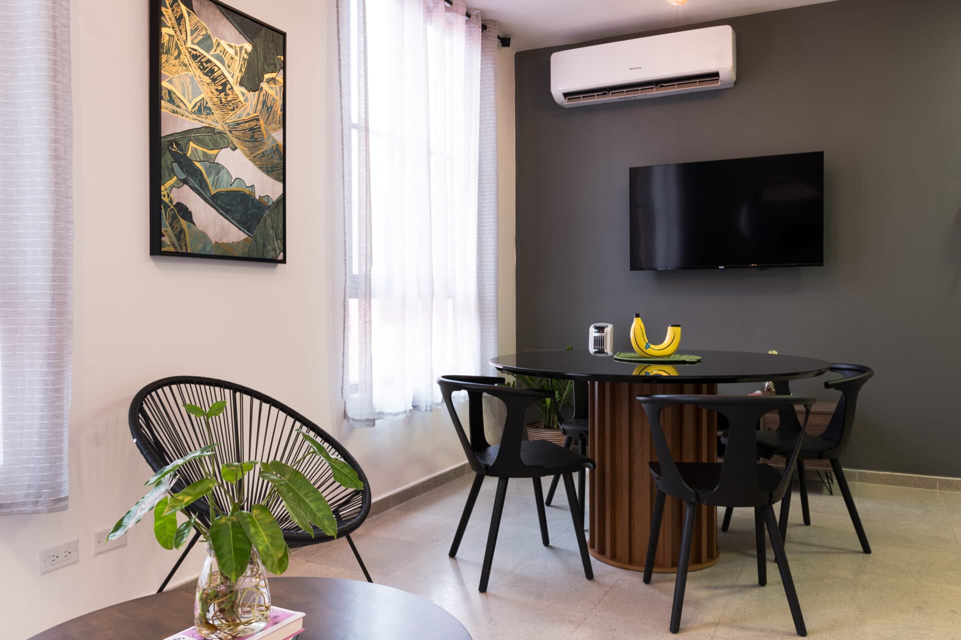 Dining area with a round table and wall-mounted TV in a La Quince apartment