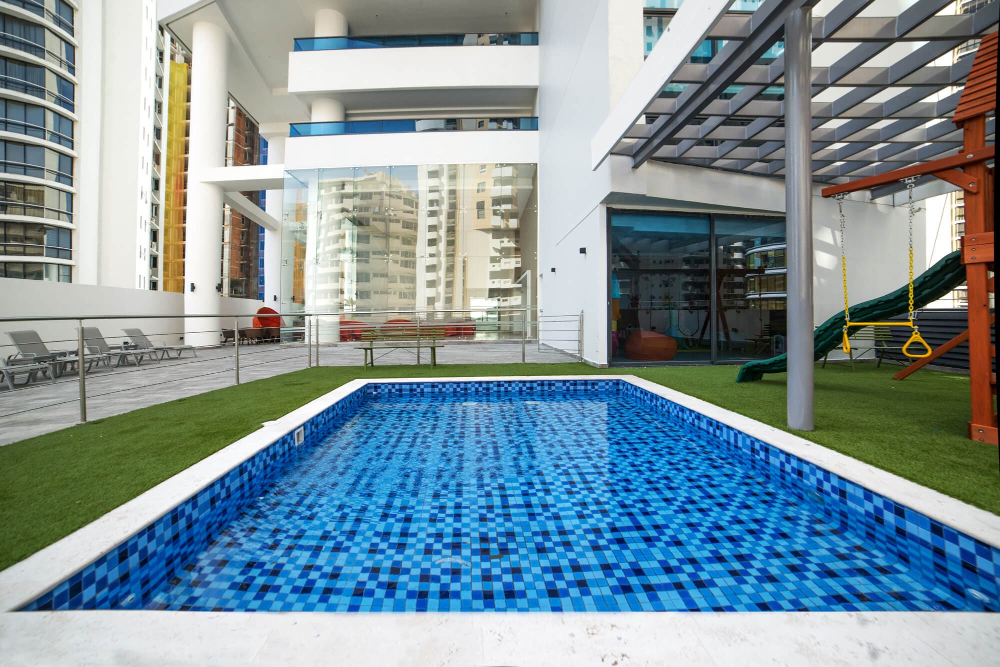 Deluxe Residences pool deck with lawn and children's play area