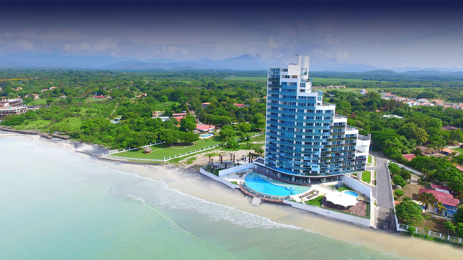 Ocean Waves aerial view of the curved beachfront tower in Nueva Gorgona