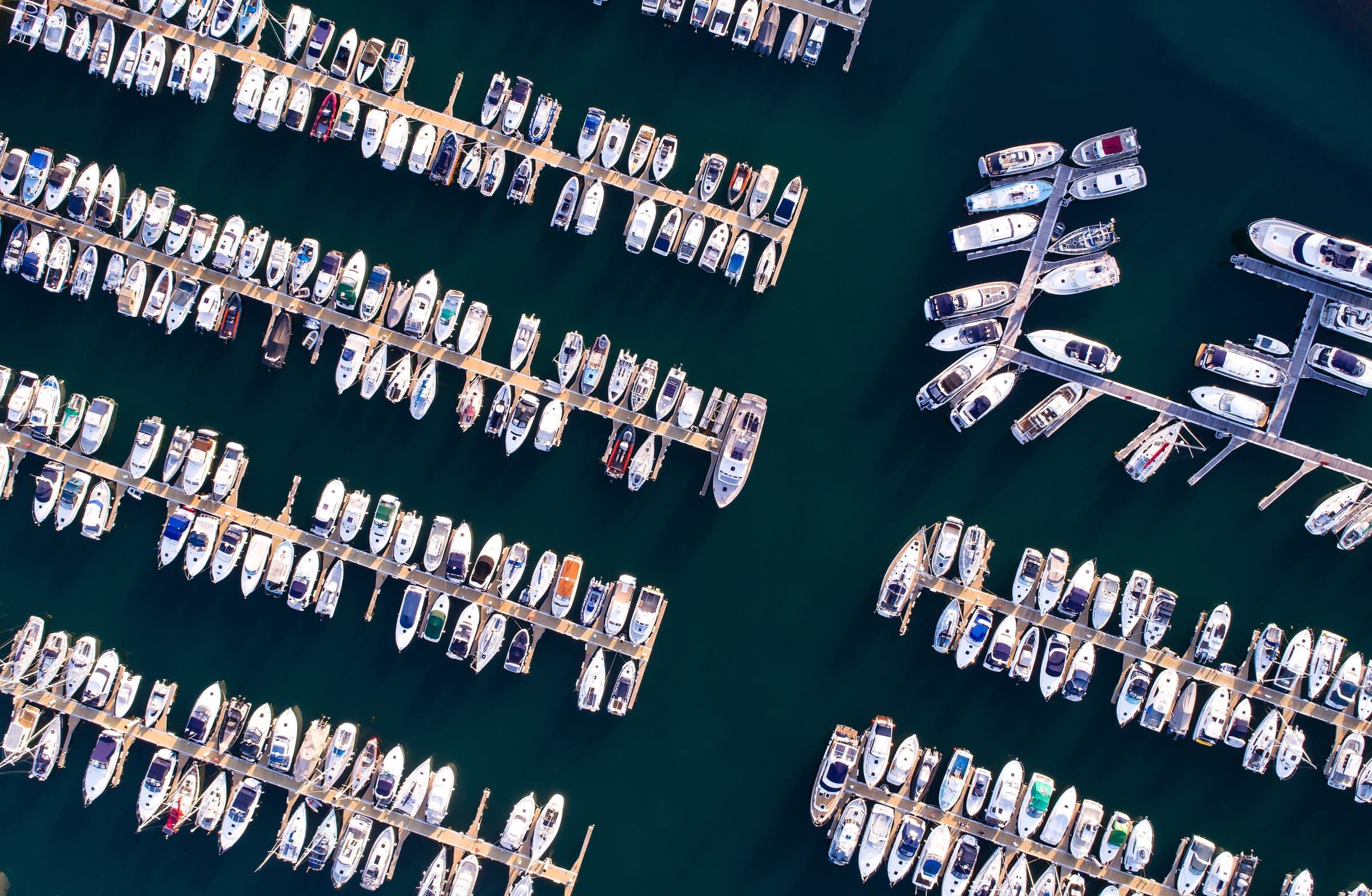Aerial view of yachts and motorboats moored along the docks of a marina